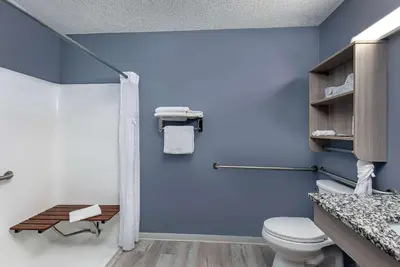 a bathroom with a toilet and a blue wall at Microtel Inn & Suites by Wyndham Dry Ridge in Dry Ridge