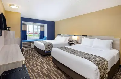 a hotel room with two beds and a television at Microtel Inn & Suites by Wyndham Dry Ridge in Dry Ridge