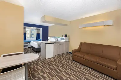 a living room with a couch and a bed at Microtel Inn & Suites by Wyndham Dry Ridge in Dry Ridge