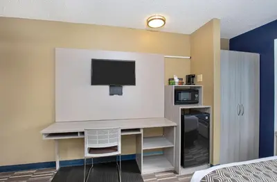 a room with a desk with a tv and a bed at Microtel Inn & Suites by Wyndham Dry Ridge in Dry Ridge