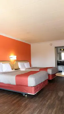 two beds in a hotel room with orange walls at Motel 6-Dayton, OH in Dayton