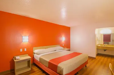 a bedroom with a bed with an orange wall at Motel 6-Dayton, OH in Dayton