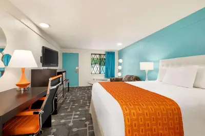 a hotel room with a large bed and a television at Dover Inn and Suites in Dover