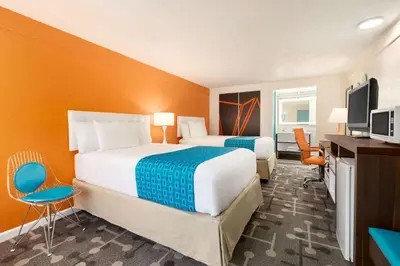 a hotel room with two beds and a television at Dover Inn and Suites in Dover