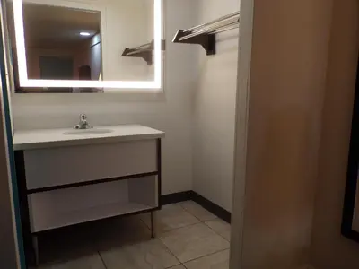 a bathroom with a sink and a mirror at Dover Inn and Suites in Dover