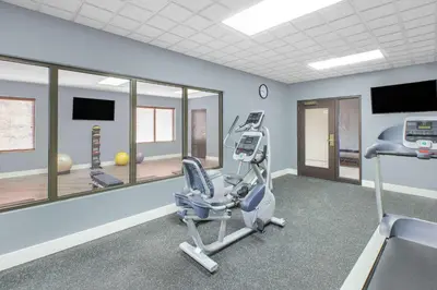 a gym with a treadmill and a chair in a room at Wingate by Wyndham Sylvania-Toledo in Sylvania