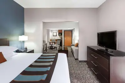 a hotel room with a bed and a flat screen tv at Wingate by Wyndham Sylvania-Toledo in Sylvania