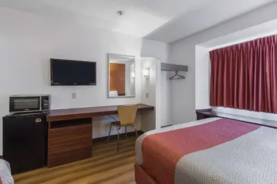 a hotel room with a bed and a desk with a television at Motel 6-Streetsboro, OH in Streetsboro