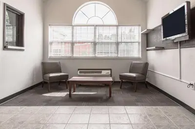 a waiting room with two chairs and a table and a tv at Motel 6-Streetsboro, OH in Streetsboro