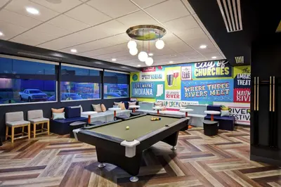 a billiard room with a pool table and signs at Tru By Hilton Fort Wayne in Fort Wayne