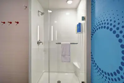 a bathroom with a shower with a glass door at Tru By Hilton Fort Wayne in Fort Wayne