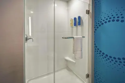 a bathroom with a shower with a glass door at Tru By Hilton Fort Wayne in Fort Wayne