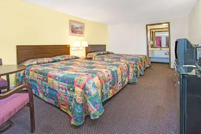 a hotel room with two beds and a table at Guest Inn Lebanon (Ohio) in Lebanon