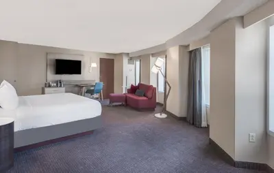 a hotel room with a bed and a living room at Crowne Plaza Cleveland at Playhouse Square by IHG in Cleveland