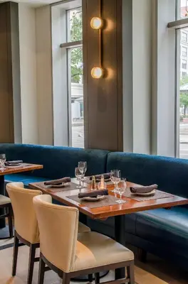 a restaurant with a table and chairs and a blue couch at Crowne Plaza Cleveland at Playhouse Square by IHG in Cleveland
