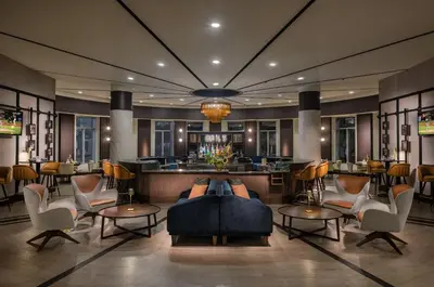 a hotel lobby with a couch and chairs and a bar at Crowne Plaza Cleveland at Playhouse Square by IHG in Cleveland