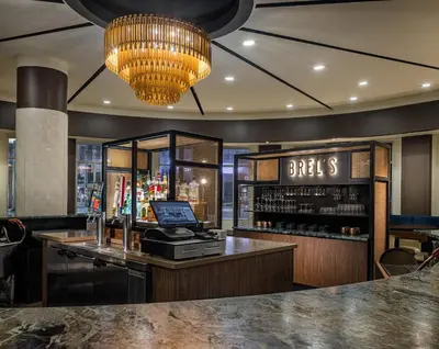 a bar with a cash register and a chandelier at Crowne Plaza Cleveland at Playhouse Square by IHG in Cleveland