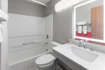 a bathroom with a toilet and a sink and a mirror at Super 8 by Wyndham Kent/Akron Area in Kent