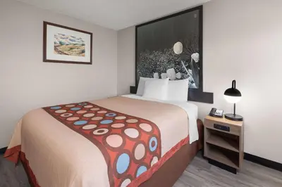 a hotel room with a large bed and a side table at Super 8 by Wyndham Kent/Akron Area in Kent