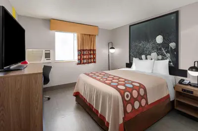 a hotel room with a bed and a flat screen tv at Super 8 by Wyndham Kent/Akron Area in Kent