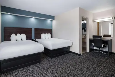 a hotel room with two beds and a desk at Baymont by Wyndham Boardman in Boardman