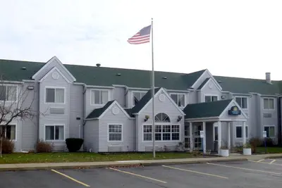a large white building with an american flag in front at Baymont by Wyndham Boardman in Boardman