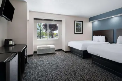 a hotel room with two beds and a television at Baymont by Wyndham Boardman in Boardman