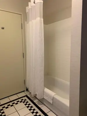 a bathroom with a shower with a white shower curtain at Fairfield Inn & Suites by Marriott Marietta in Marietta