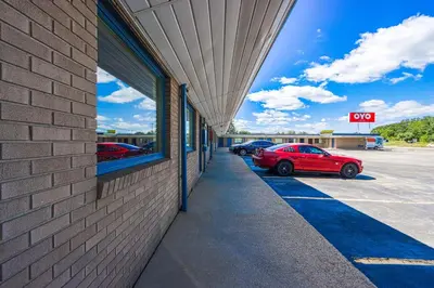 a red car parked in a parking lot next to a building at OYO Hotel North Lima OH - Boardman in North Lima