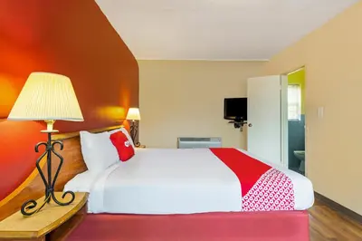 a bedroom with a white bed and a lamp at OYO Hotel North Lima OH - Boardman in North Lima