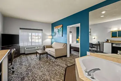 a hotel room with a tub and a bedroom at Best Western Fort Wayne Inn & Suites North in Fort Wayne