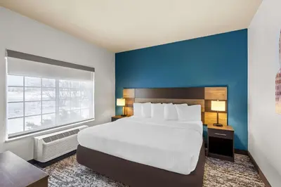a bedroom with a large bed and a blue wall at Best Western Fort Wayne Inn & Suites North in Fort Wayne