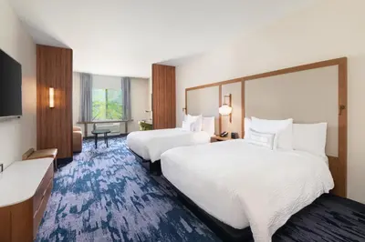 a hotel room with two beds and a television at Fairfield Inn & Suites by Marriott Lexington East/I-75 in Lexington