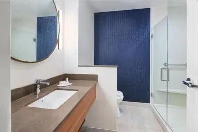 a bathroom with a sink and a toilet and a mirror at Fairfield Inn & Suites by Marriott Lexington East/I-75 in Lexington