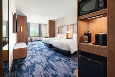 a hotel room with two beds and a flat screen tv at Fairfield Inn & Suites by Marriott Lexington East/I-75 in Lexington