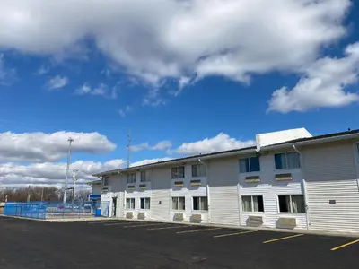 a white building in front of a parking lot at Motel 6-Fort Wayne, IN in Fort Wayne