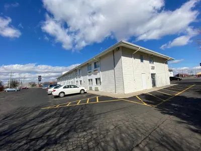 a building with a car parked in a parking lot at Motel 6-Fort Wayne, IN in Fort Wayne