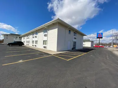 a large white building with a parking lot at Motel 6-Fort Wayne, IN in Fort Wayne