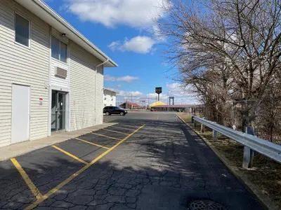a parking lot with a car parked next to a building at Motel 6-Fort Wayne, IN in Fort Wayne