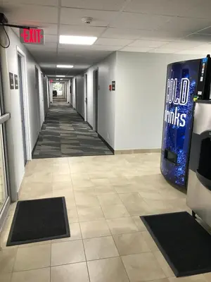 an empty hallway in a building with a sign on the wall at Motel 6-Fort Wayne, IN in Fort Wayne