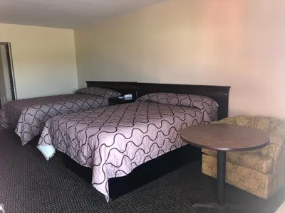 a hotel room with a bed and a table and a couch at Harcourt Motel in Mount Vernon