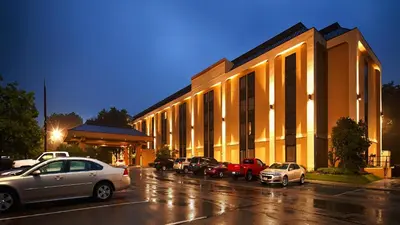 a building with cars parked in a parking lot at Days Inn by Wyndham Englewood Dayton Airport in Dayton