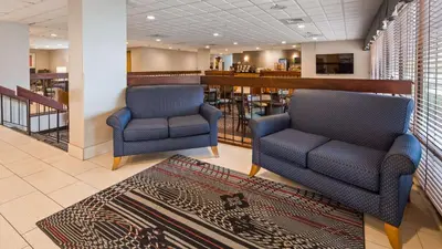 a lobby with two chairs and a bar at Days Inn by Wyndham Englewood Dayton Airport in Dayton