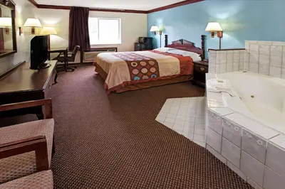 a hotel room with a bed and a bath tub at Super 8 by Wyndham Heath/Newark in Heath