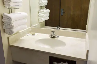 a bathroom with a sink and a mirror and towels at Super 8 by Wyndham Heath/Newark in Heath