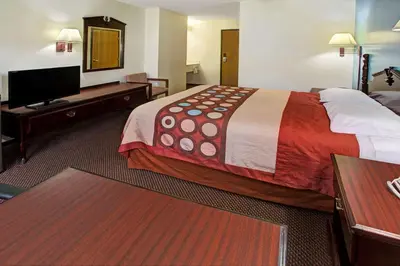 a hotel room with a bed and a flat screen tv at Super 8 by Wyndham Heath/Newark in Heath