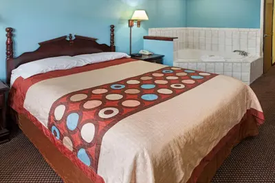 a large bed in a hotel room with a large bedspread at Super 8 by Wyndham Heath/Newark in Heath