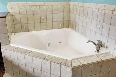 a white bath tub with a faucet in a bathroom at Super 8 by Wyndham Heath/Newark in Heath