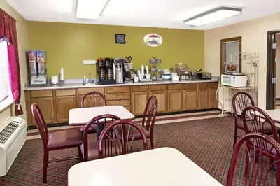 a restaurant with tables and chairs and a counter at Super 8 by Wyndham Heath/Newark in Heath