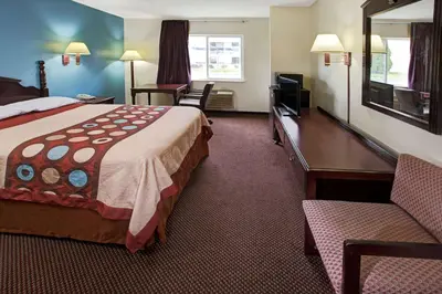 a hotel room with a bed and a desk and a television at Super 8 by Wyndham Heath/Newark in Heath